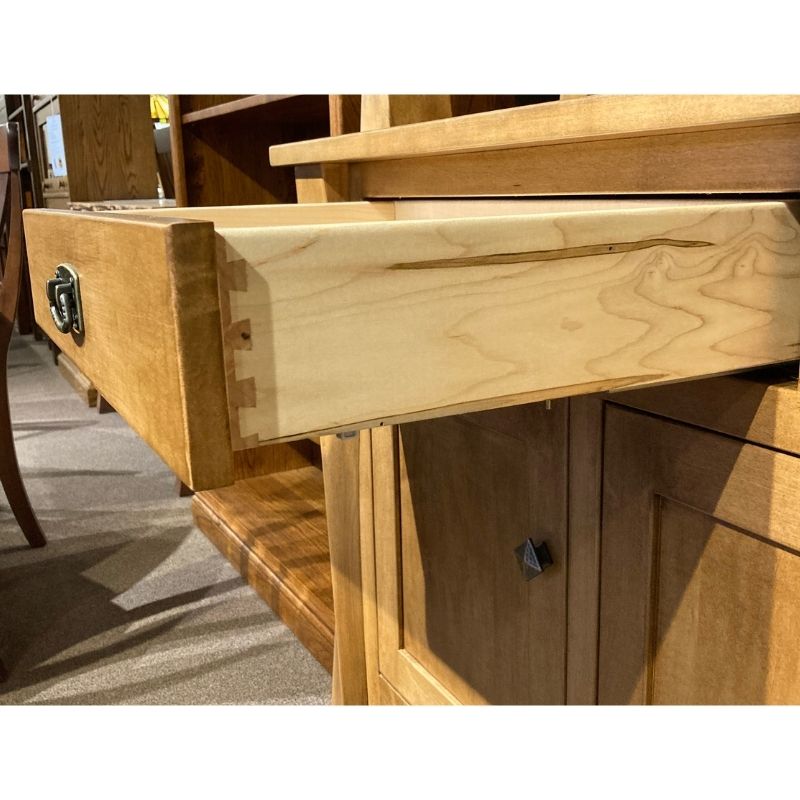 Close up view of one wood drawer open on the hard maple wood buffet in a showroom setting - Amish Furniture Creations™
