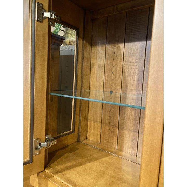 Close up view of one glass shelf on the hard maple wood hutch top in a showroom setting - Amish Furniture Creations™