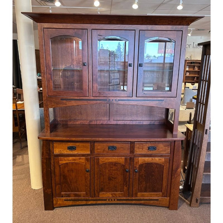 Clearance cherry wood hutch with glass doors on top of a buffet with drawers and doors in a showroom setting - front view - Amish Furniture Creations™