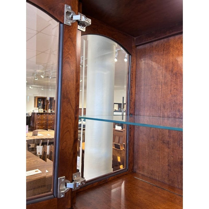 Close up view of one glass shelf on the cherry wood hutch top in a showroom setting - Amish Furniture Creations™